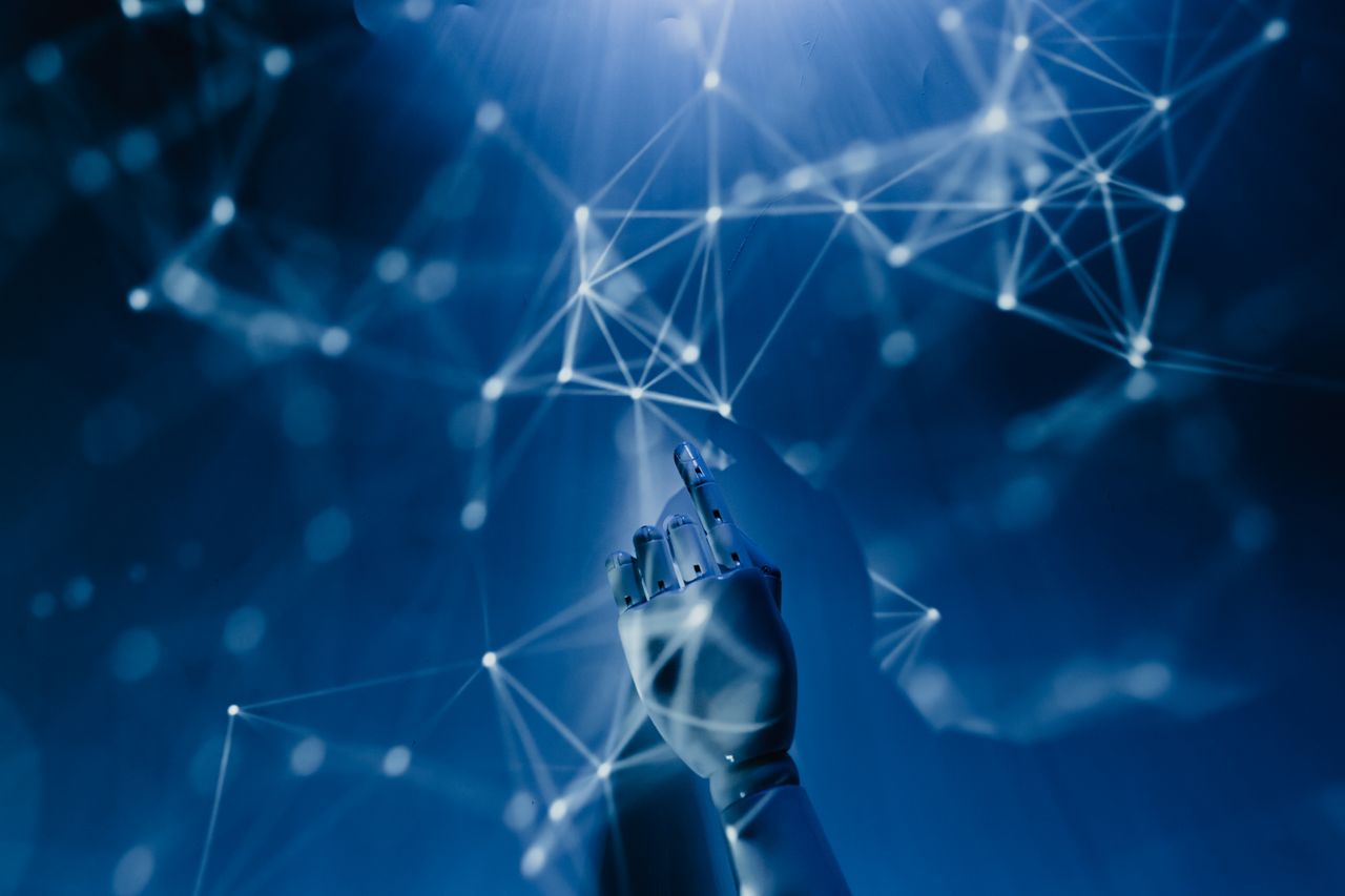 机器人之手伸向数字网络,象征 AI 技术(Pexels 免费商用)